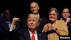 El presidente Trump junto a la expresa política cubana Cary Roque, en el Teatro Manuel Artime de Miami, el 16 de junio de 2017.