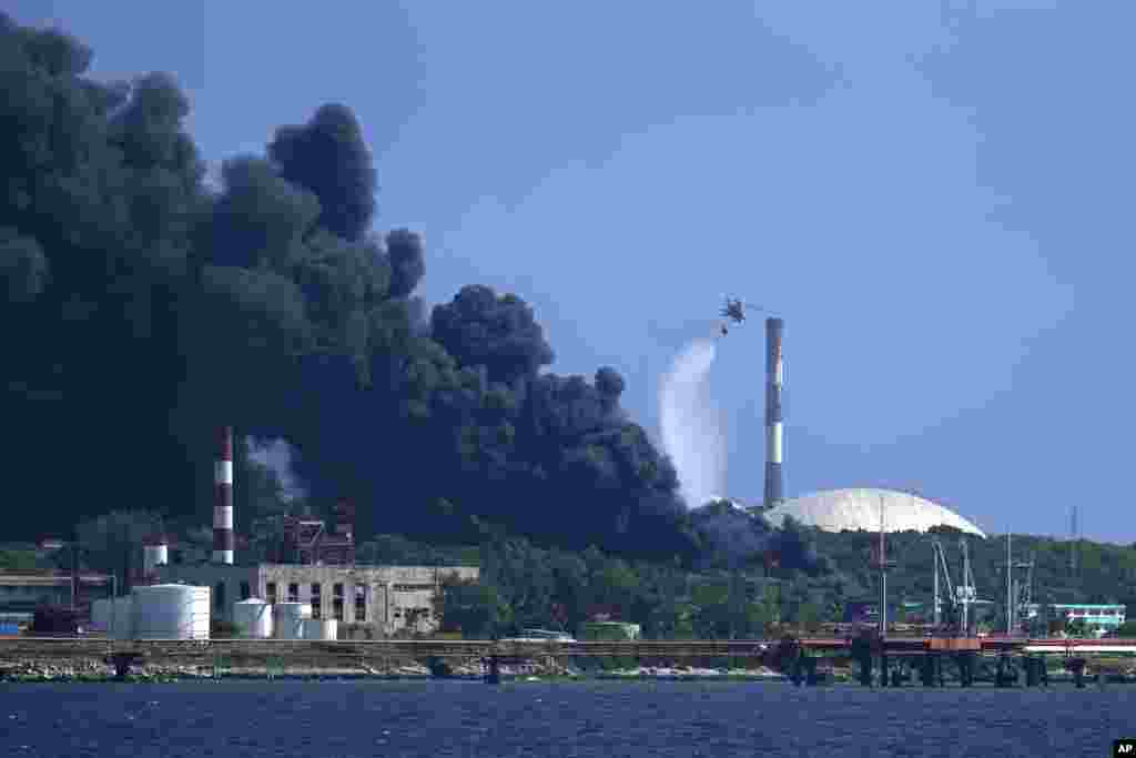 Un helicóptero arroja agua sobre el incendio. 