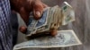 Un hombre sostiene pesos cubanos. REUTERS/Desmond Boylan