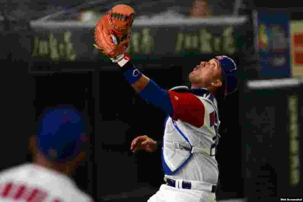 El receptor cubano Frank Morejón intenta capturar un batazo foul.