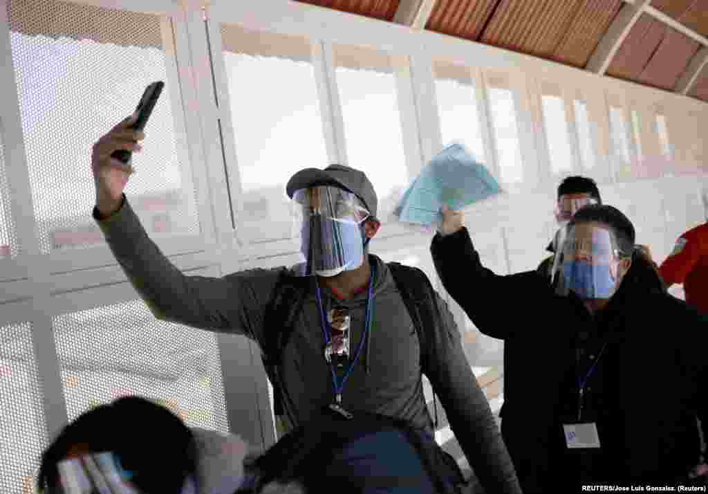 Mikel Riviaux y Pedro Luis Ruiz migrantes cubanos bajo el Programa de Protección de Migrantes (MPP) por sus siglas en inglés caminan el puente de la frontera internacional El Paso Norte desde Ciudad Juárez, México hacia El Paso Texas, Estados Unidos para poder continuar sus trámites de asilo, mientras se toman un selfie. Foto: tomada el 11 de marzo de 2021 por REUTERS/José Luis González.