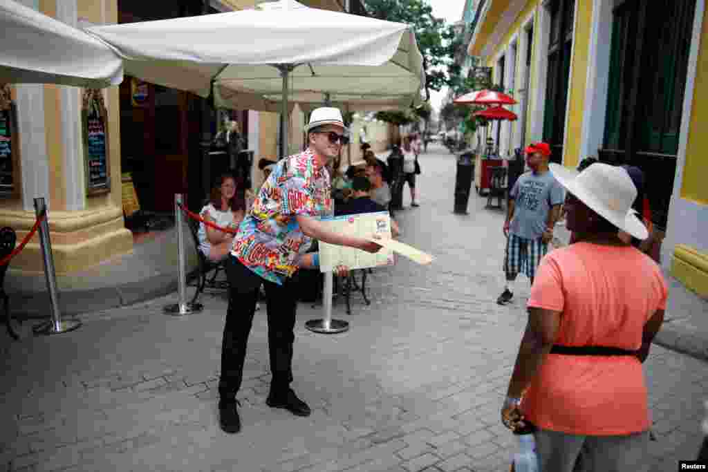 Eric Barreto, del restaurante La Vitrola, muestra el menú a los turistas en La Habana. REUTERS/Fernando Medina