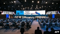 Una pantalla digital muestra el juego de béisbol y softbol como uno de los cinco nuevos deportes en los Juegos Olímpicos de 2028 en Los Ángeles, durante el segundo día de la 141.ª sesión del Comité Olímpico Internacional (COI) en Mumbai. AFP/ INDRANIL MUKHERJEE