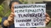 Una mujer con un cartel exige la liberación de los 3 miembros de la ONG FundaRedes