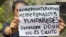 Una mujer con un cartel exige la liberación de los 3 miembros de la ONG FundaRedes