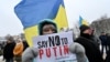"Diga NO a Putin" pide el cartel que porta una manifestante pacífica en Ucrania