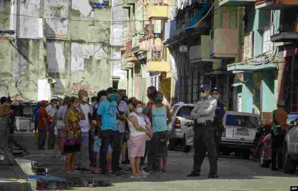 Policías en La Habana controla hilera de compradores en tiendas para comprar con dólares de EEUU.