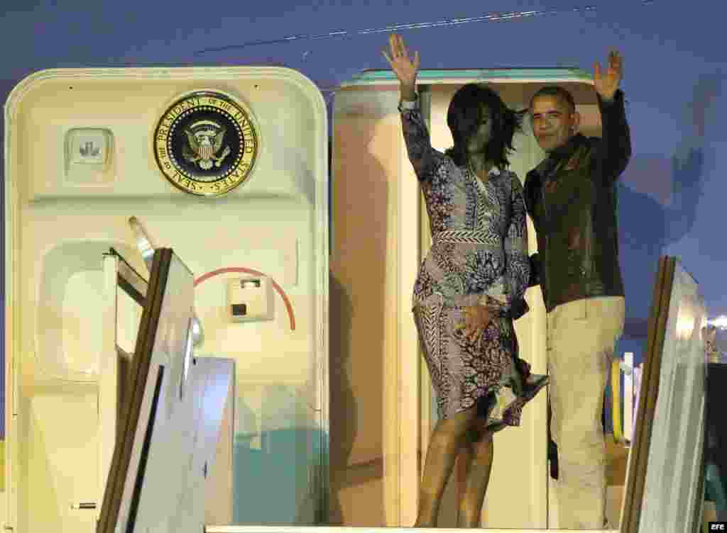 Barack Obama (d) y su esposa Michelle Obama (i) se despiden antes de ingresar al avión presidencial Air Force One.