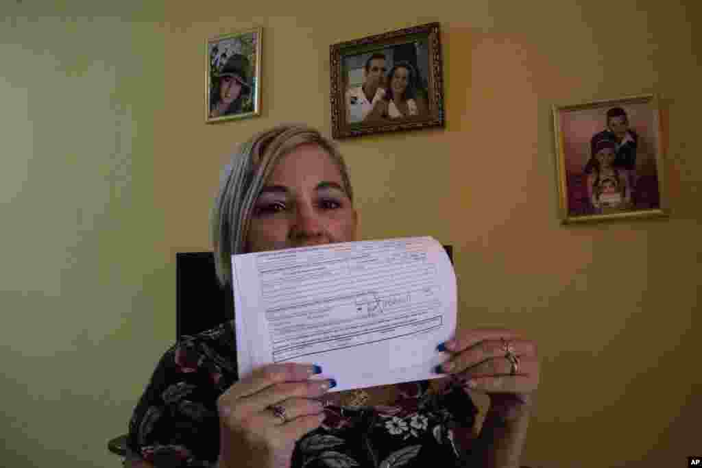 Danmara Triana muestra el documento, fechado en septiembre de 2017, empleado por su esposo para iniciar el proceso de reunificación familiar. (AP Foto/Ramón Espinosa)