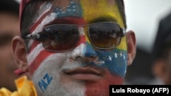 Un hombre lleva pintadas en el rostro las banderas de EEUU y Venezuela.