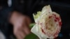 Una mujer sostiene una rosa "ensangrentada" en señal de luto por los feminicidios. (Pedro Pardo/AFP/Archivo)